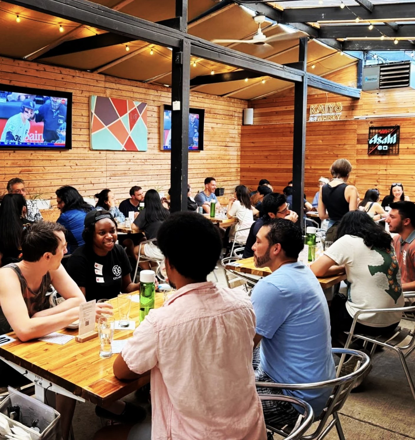 A full patio of club guests talking at tables